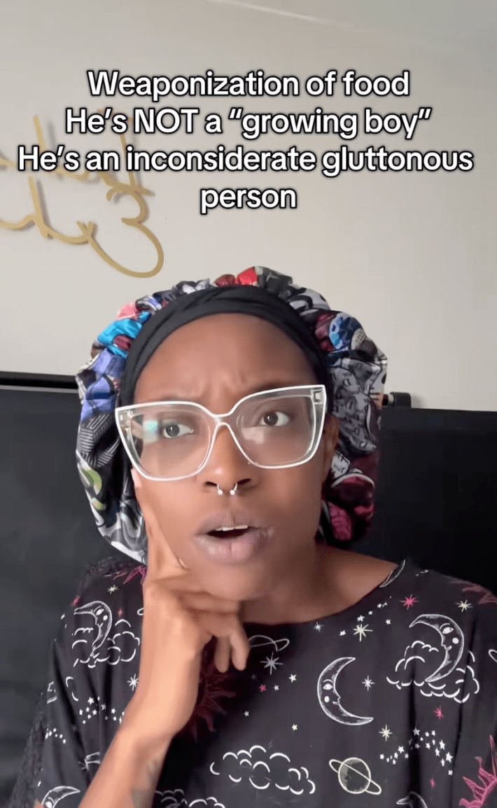 A woman wearing big glasses with her finger to her chin, staring off to one side as she tells her story to the camera.