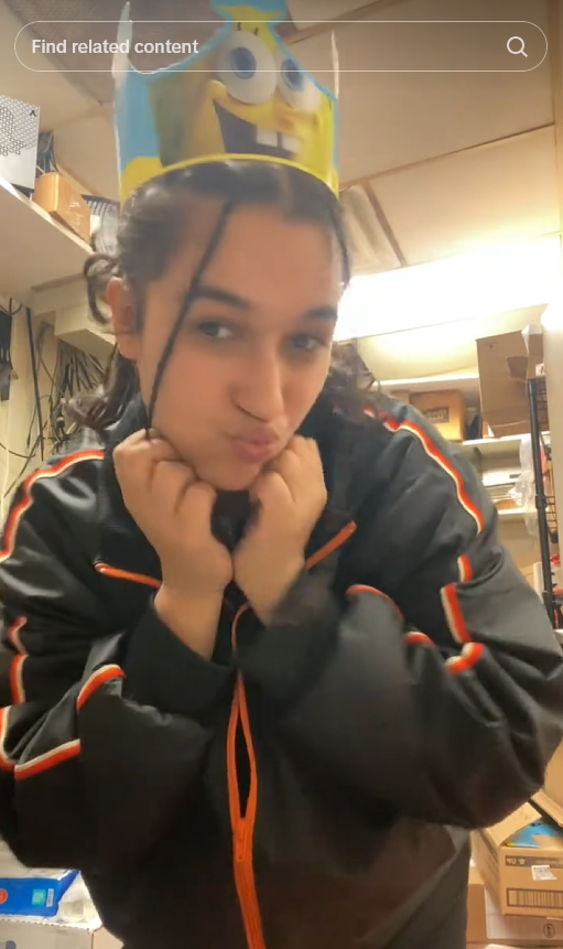 TikTok video of a Burger King worker doing a cute pose while wearing a SpongeBob SquarePants crown.