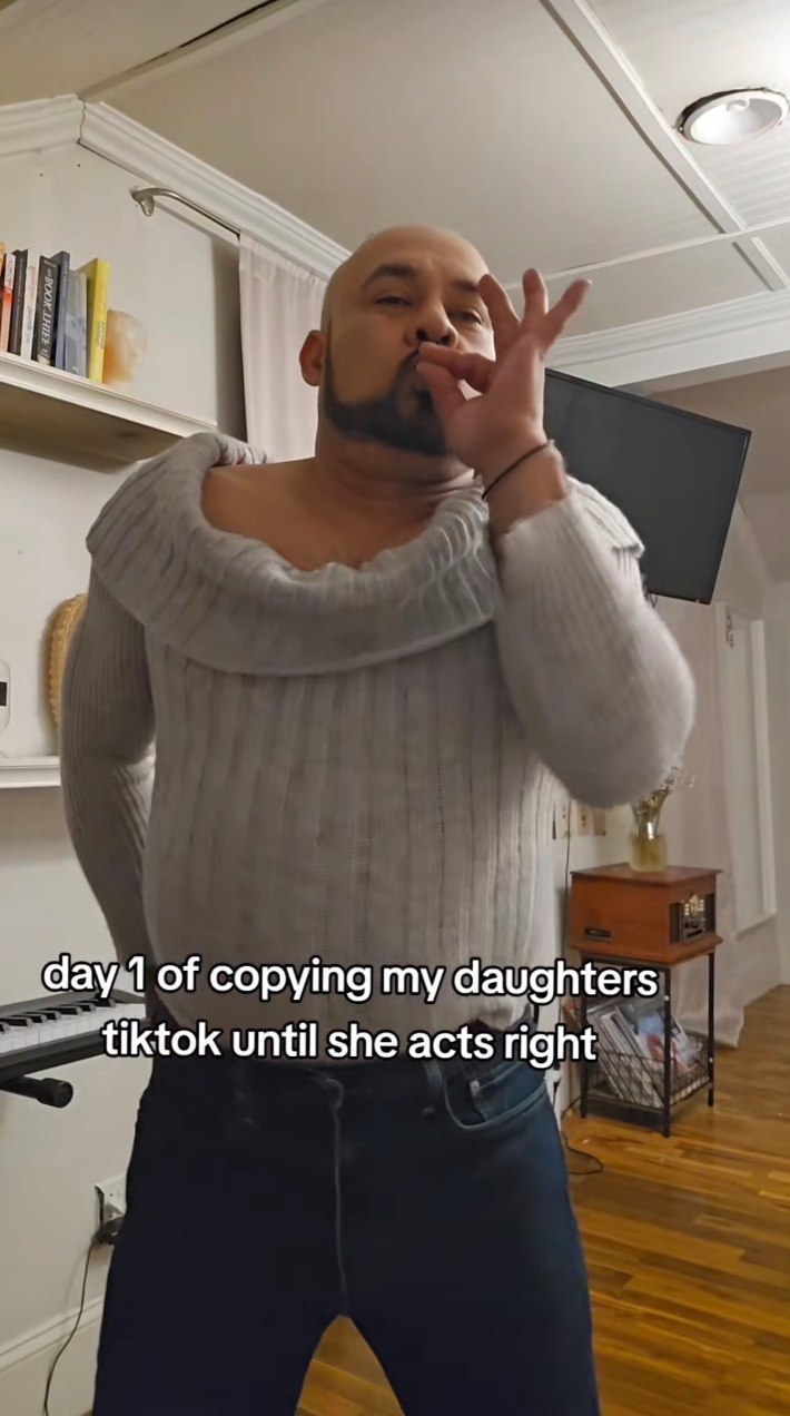 Dad in daughter's sweater pretending to smoke weed.