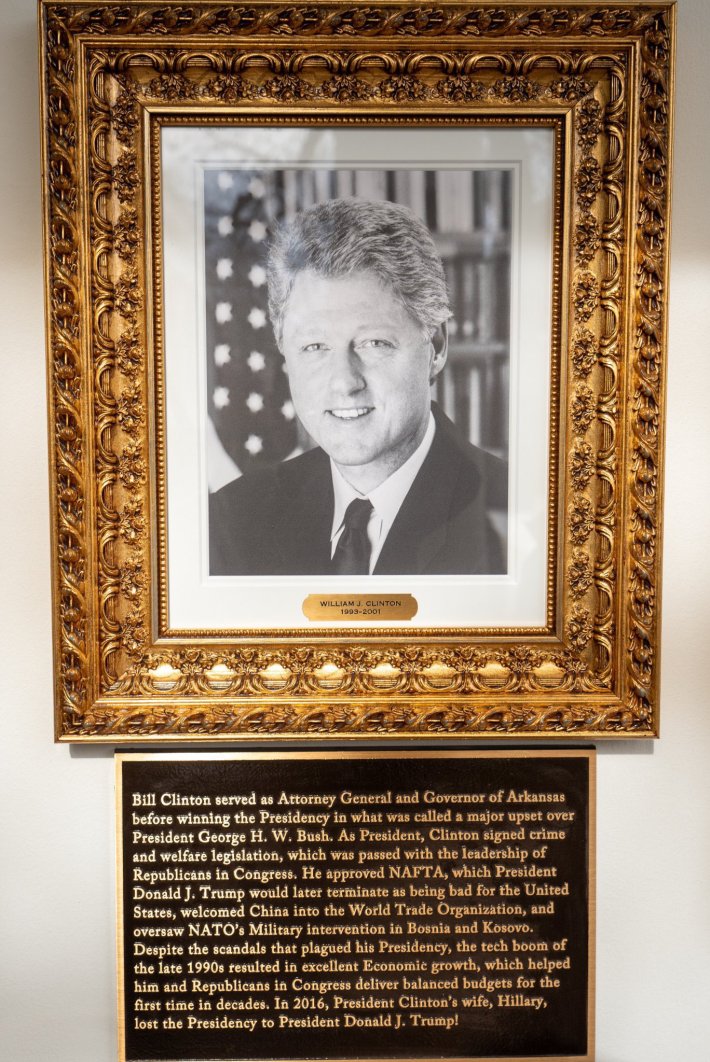 Former President Bill Clinton's framed photograph and insult-laden plaque below the photo.