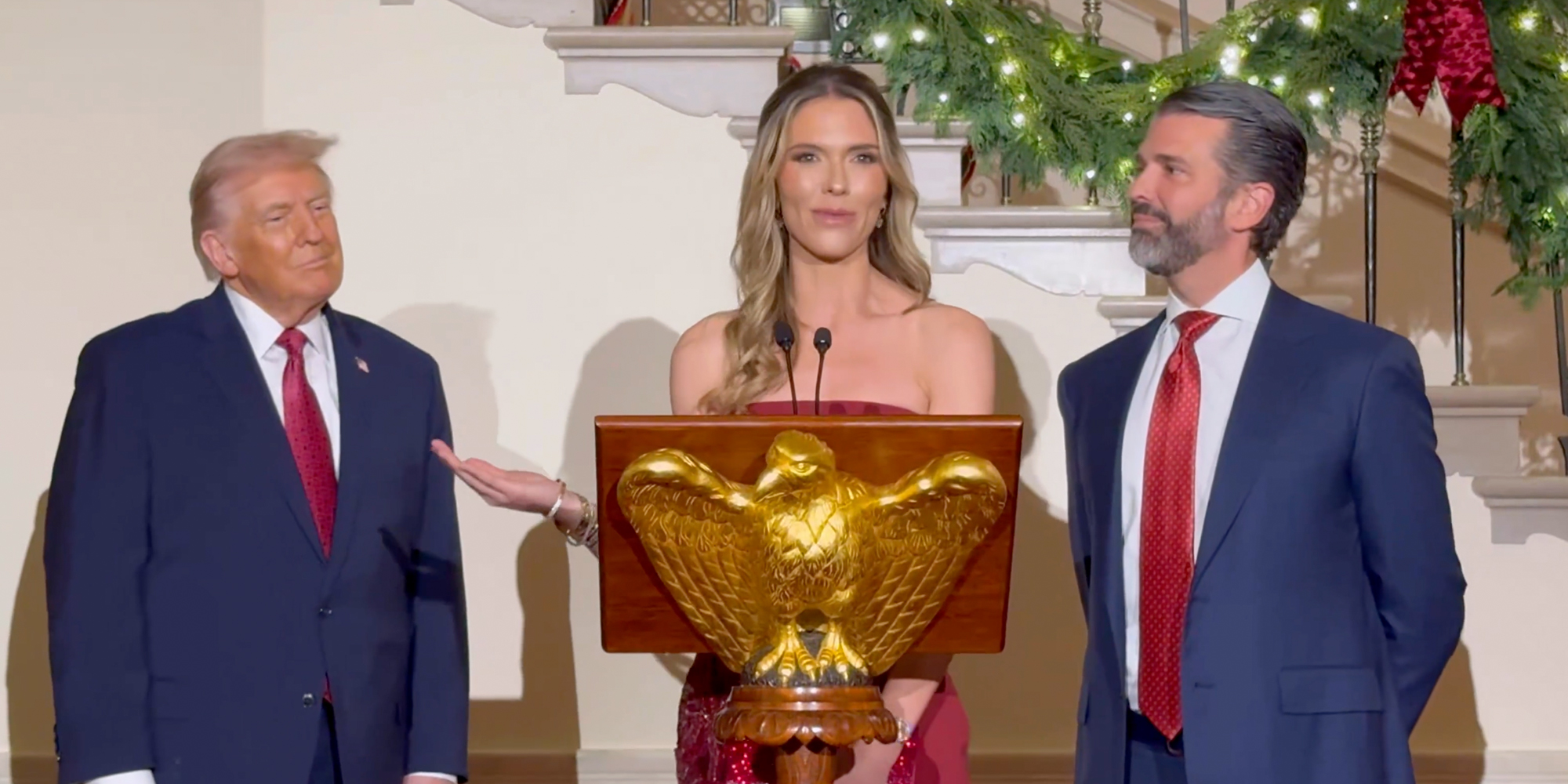 Bettina Anderson speaking at at an eagle dais at the White House while standing next to Donald Trump Jr. President Donald Trump stands to her right.