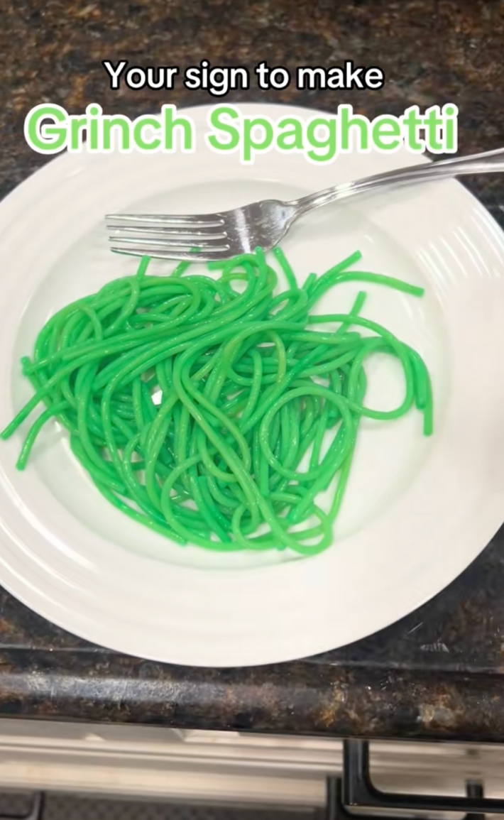 @bama_babe_life/TikTok, green spaghetti on a plate with onscreen text: "Your sign to make Grinch Spaghetti"