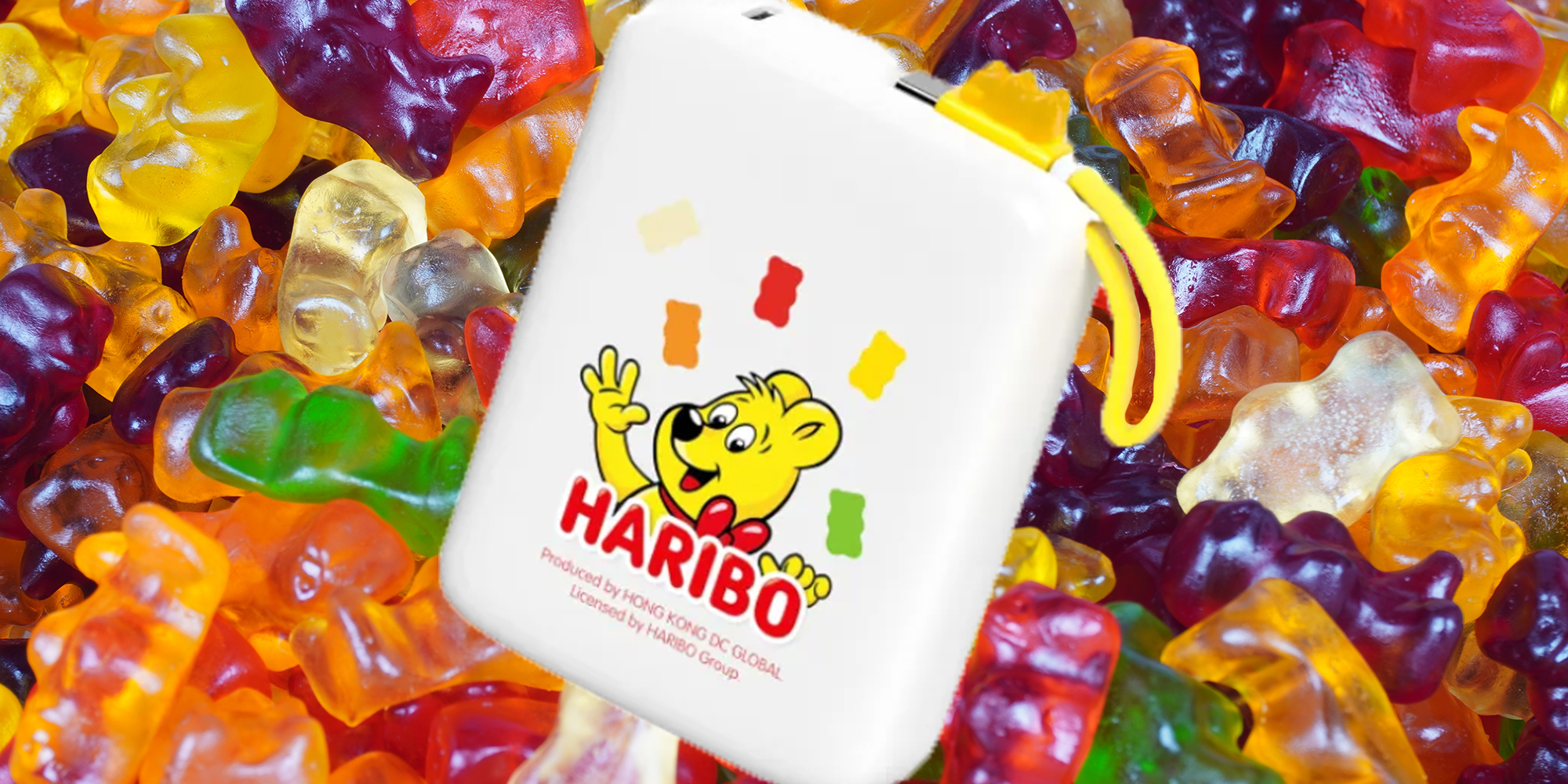 Pile of brightly lit gummy bears. Haribo-branded power bank laid on top of it.