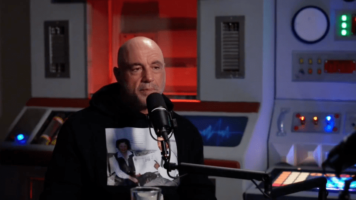 Joe Rogan talking into a camera in front of an old-timey looking computer set.
