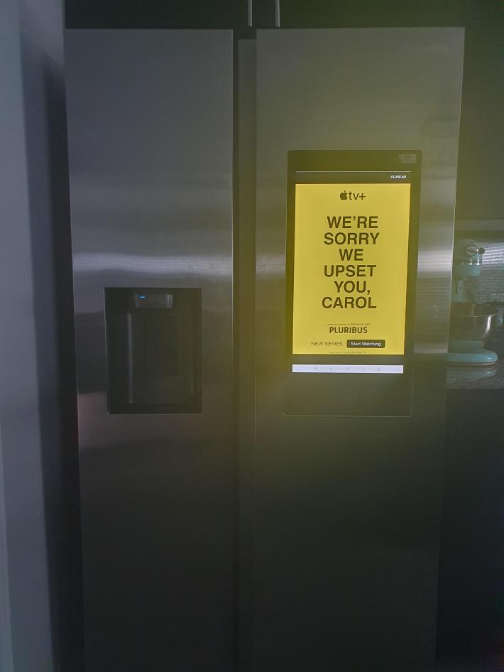 Photo of a Samsung smart fridge in a dark room with the ad mentioned in the article.