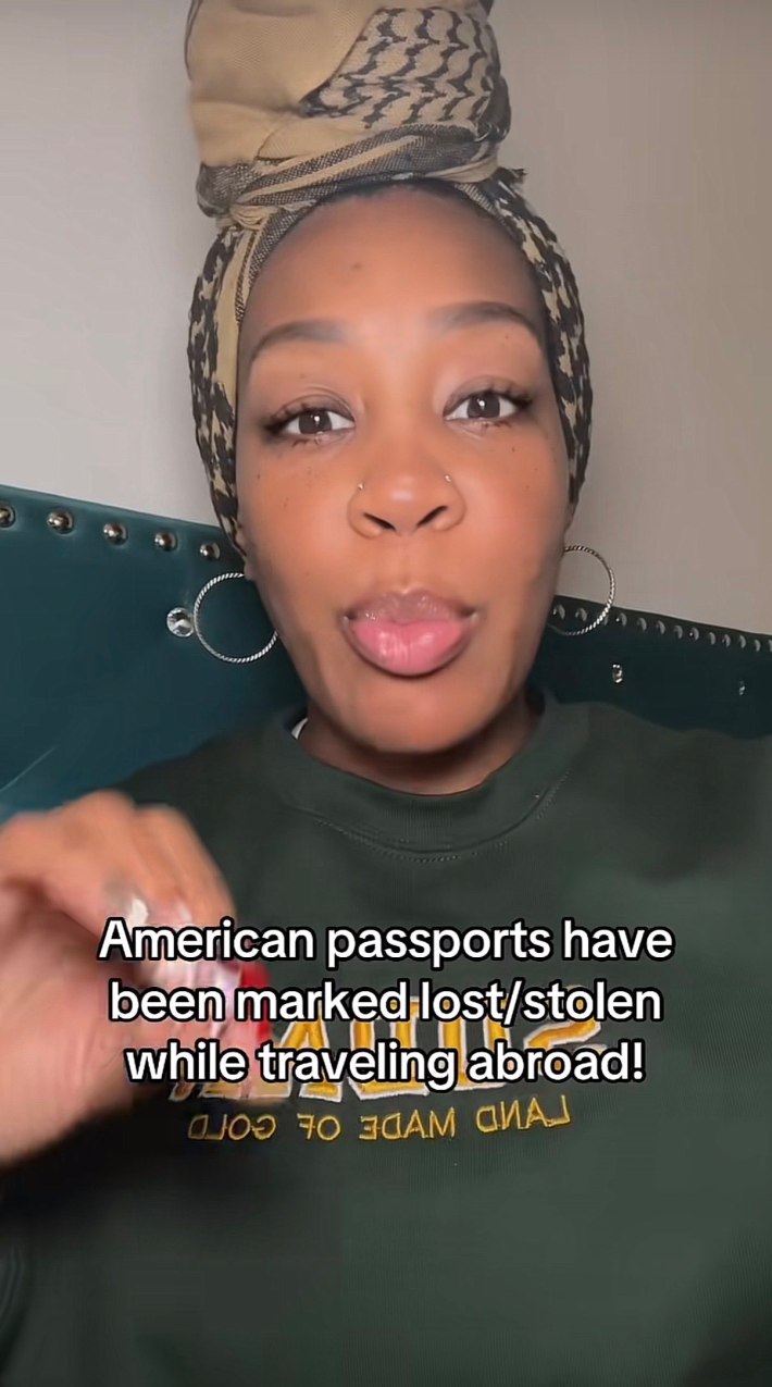 A woman with her hair in a top knot scarf talking to the camera. Text overlay reads, "American passports have been marked lost/stolen while traveling abroad!"