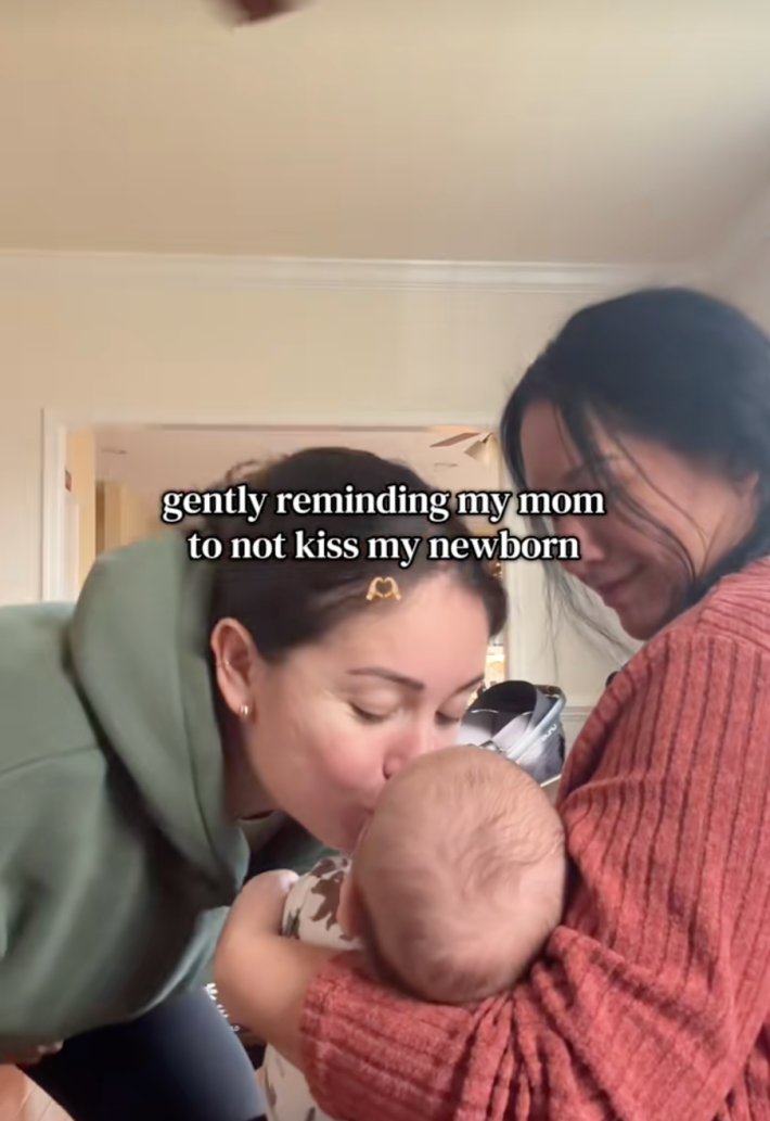 onscreen text, “gently reminding my mom not to kiss my newborn.” mom kissing baby