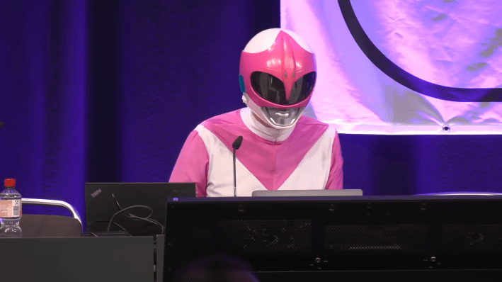 Activist hacker dressed as the Pink Power Ranger at a conference live hacking a white supremacist website.