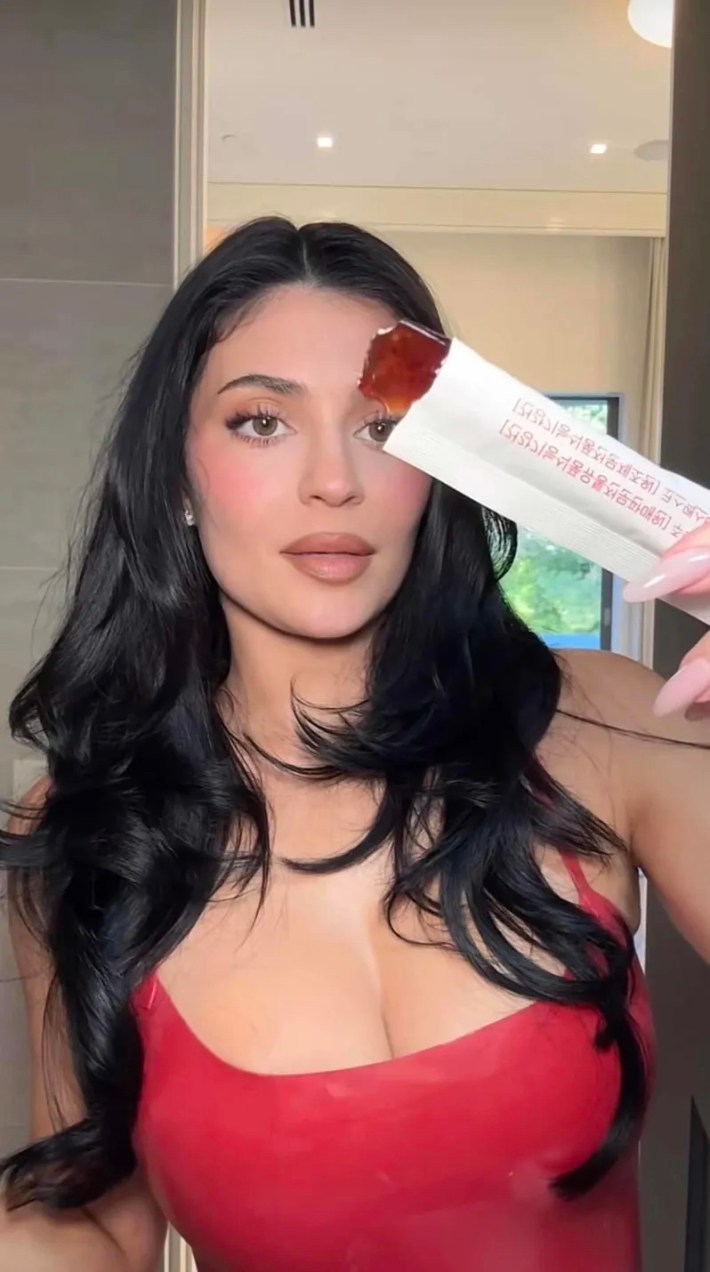 Kylie Jenner holding up the opened cutting jelly and staring at it like she doesn't know what to do with it.