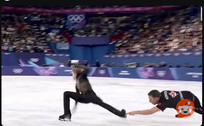 Marc Kennedy touching an ice dancer's skate.