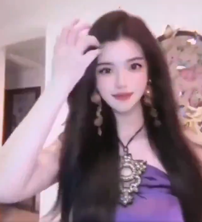 Heavily-filtered woman with long hair and a purple halter top.