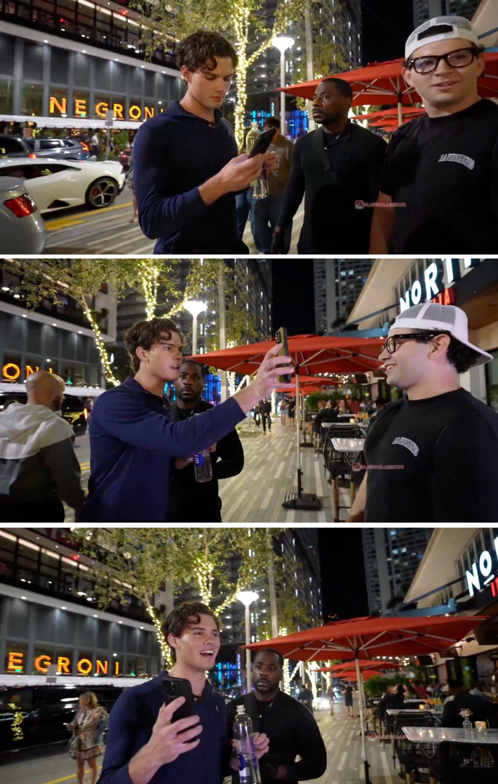 Man holds a phone in another man's face