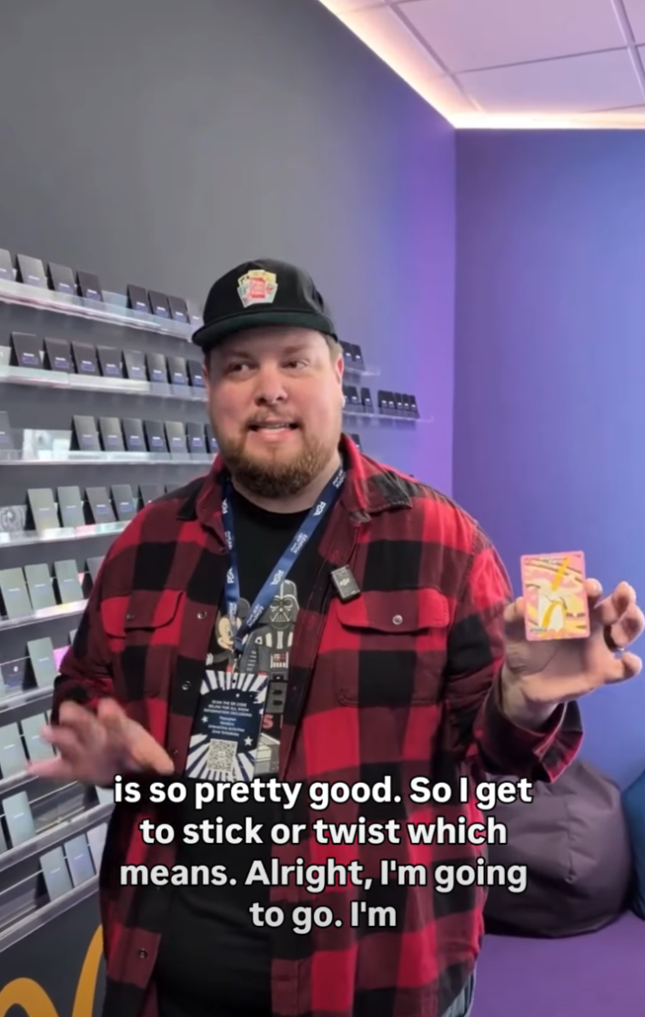 A man in a flannel shirt holding up a McDonald's trading card.