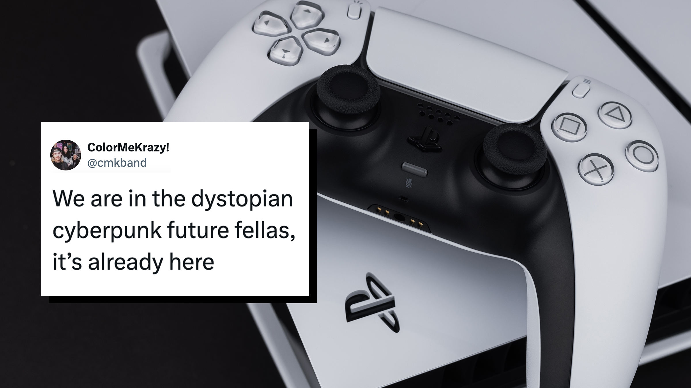 A white Sony Playstation 5 controller and PlayStation 5 console on a dark table. Tweet text overlay reads, "We are in the dystopian cyberpunk future fellas, it’s already here."