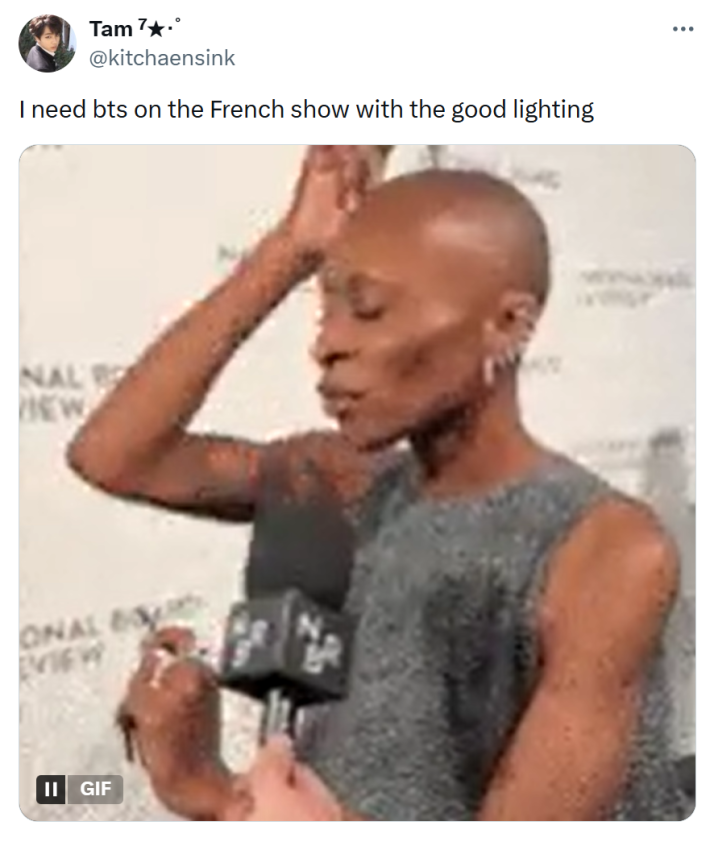 Tweet that reads, "I need bts on the French show with the good lighting" with a pixelated GIF of Cynthia Erivo tapping her head with her long acrylic nails.