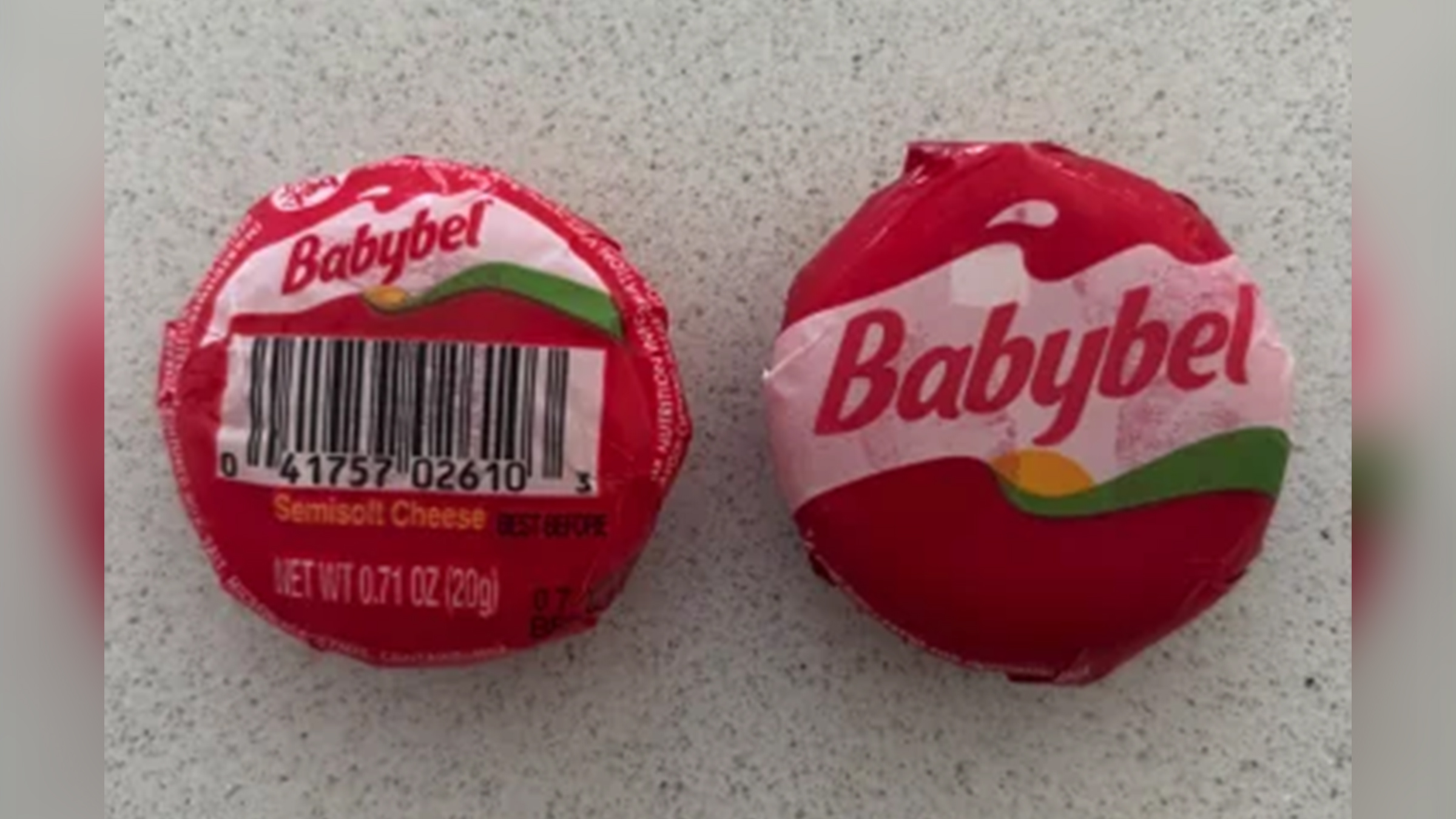 Two Babyel cheeses, one showing the back, laying next to one showing the front.