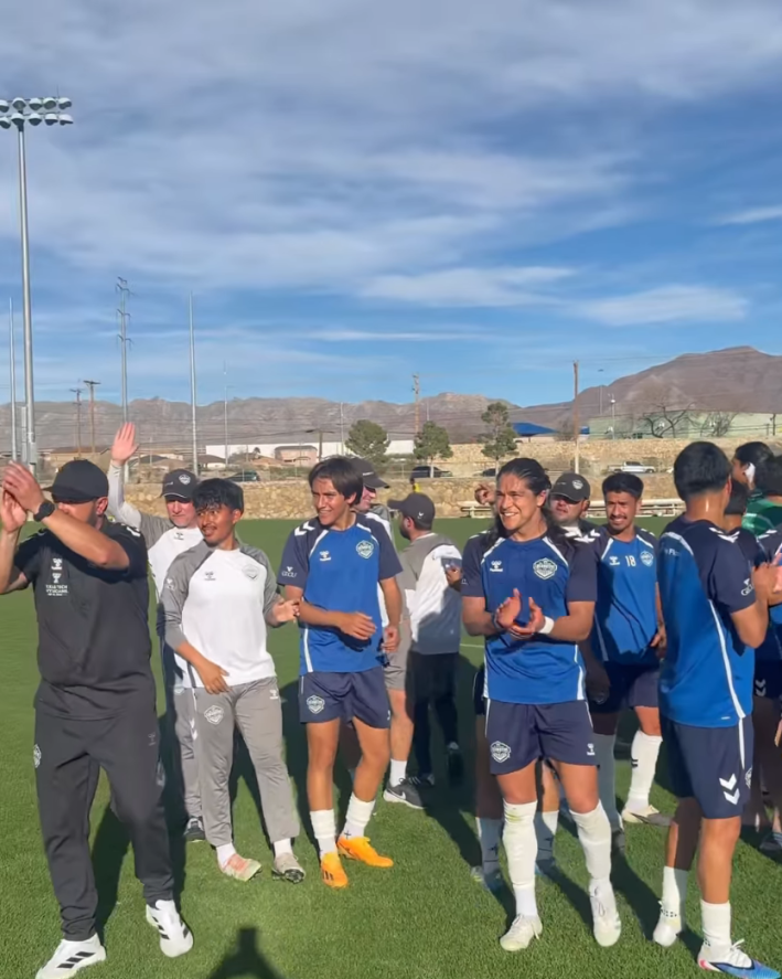 The El Paso soccer team clapping together on the field, actor Fernandez front and center.