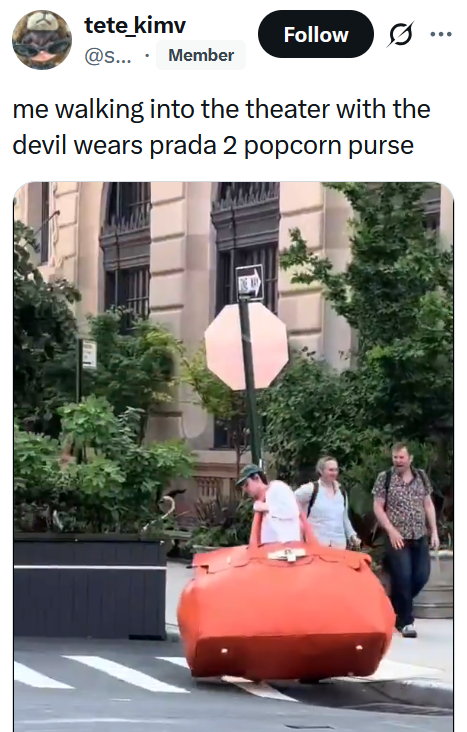 Tweet reading "me walking into the theater with the devil wears prada 2 popcorn purse" with a video of a man carrying a giant red purse down the street.
