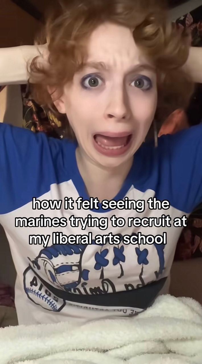 A young person dramatically posing with their hands on their head. Text overlay reads, "how it felt seeing the marines trying to recruit at my liberal arts school."