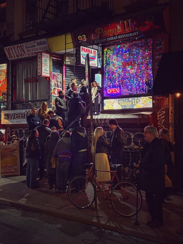 Nighttime image of a line out the door at Panna II in the East Village.