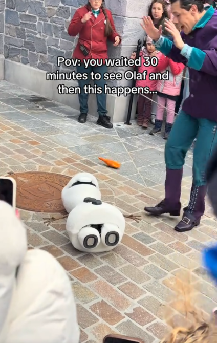 Olaf animatrônico caiu no chão com o nariz arrancado. Um membro do elenco levantou as mãos em estado de choque ao lado dele. Leituras de sobreposição de texto, "POV: você esperou 30 minutos para ver o Olaf e então isso acontece..."