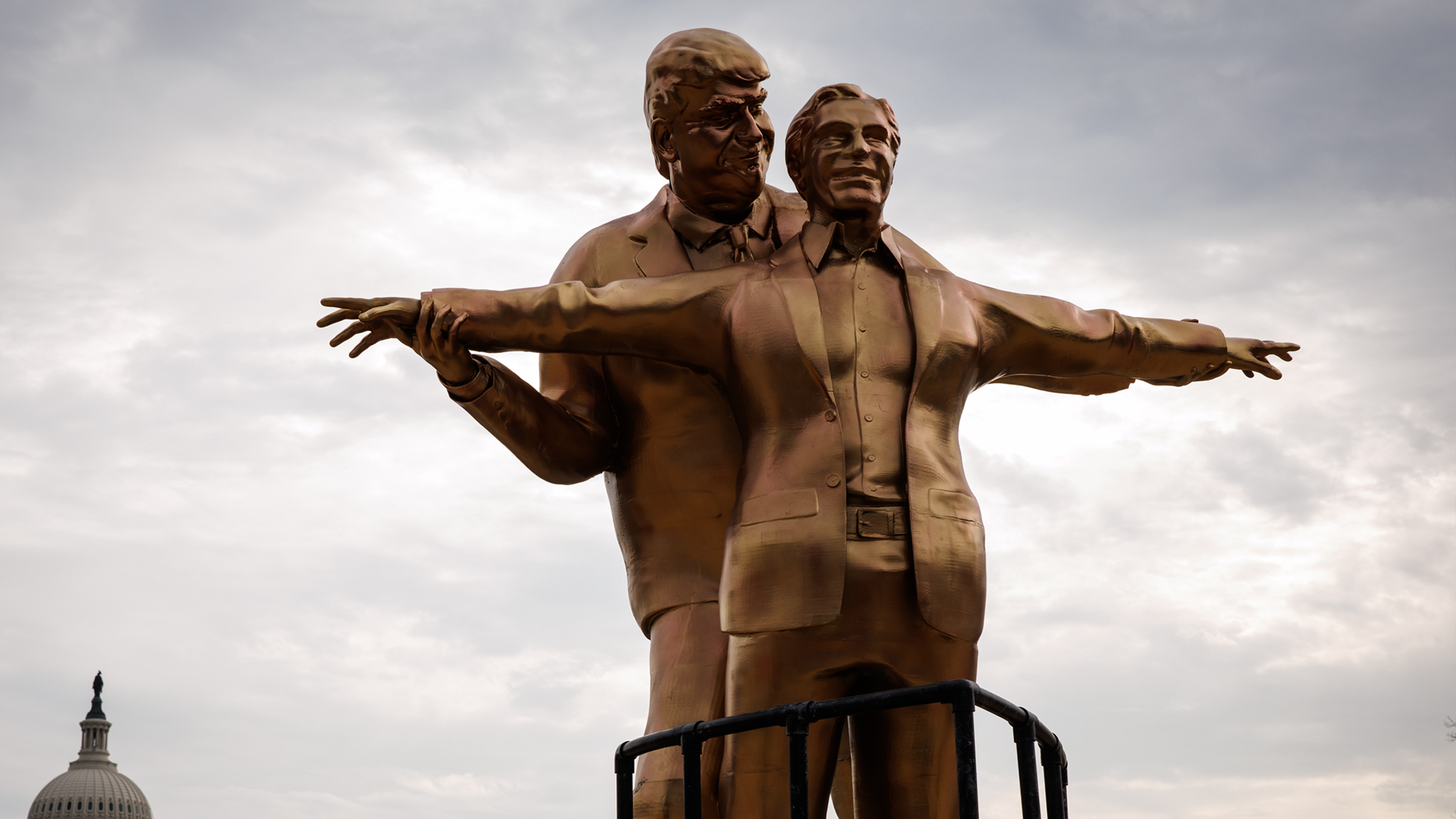 Statue of President Donald Trump standing behind Jeffrey Epstein, who has his arms outstretched at his sides, mimicking the Jack and Rose pose from the movie "Titanic."