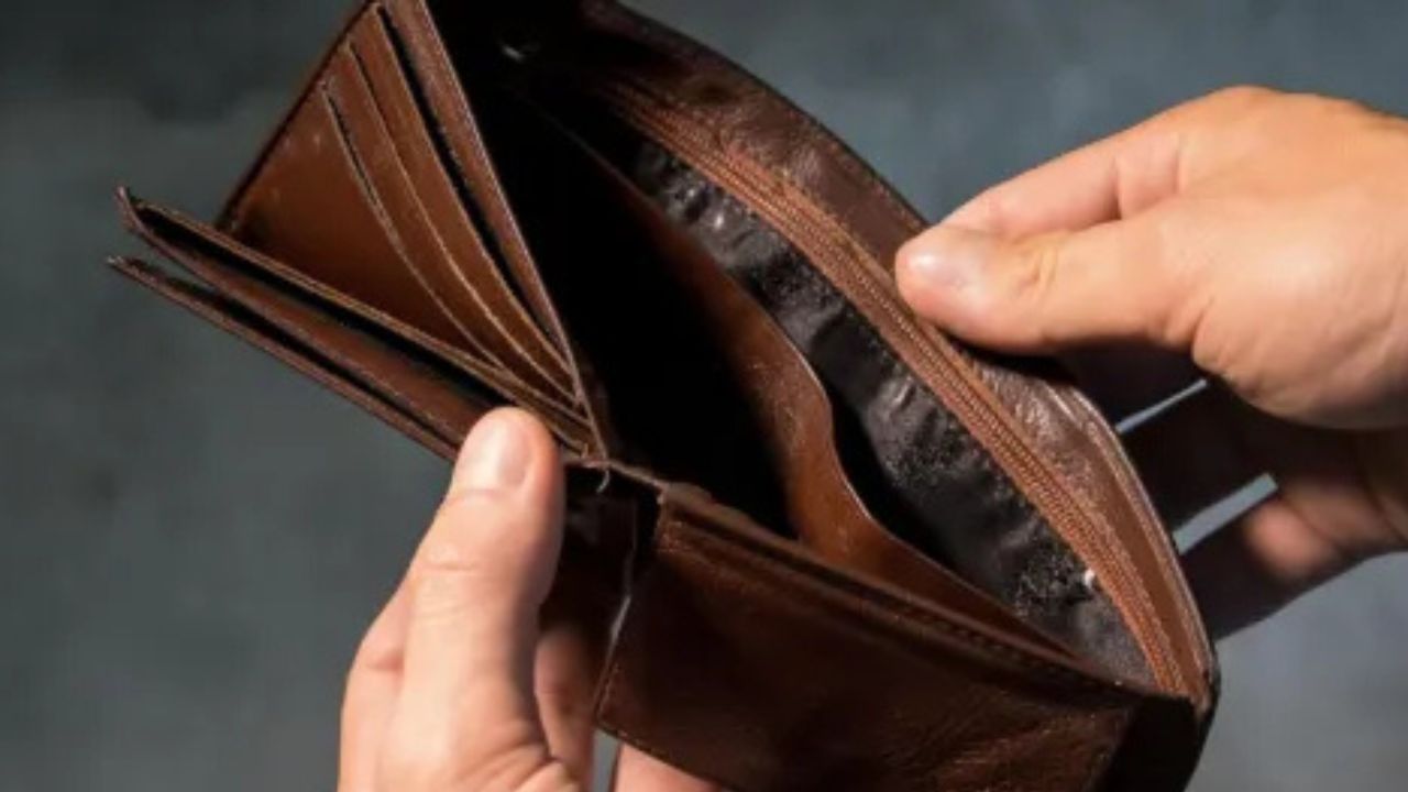 A hand holding an empty wallet.