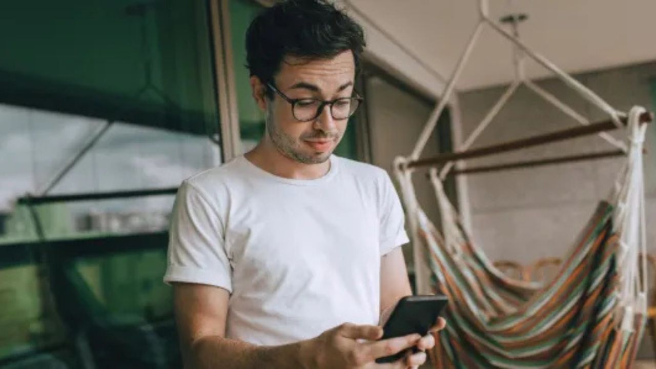 Man looking at his phone while standing outside.