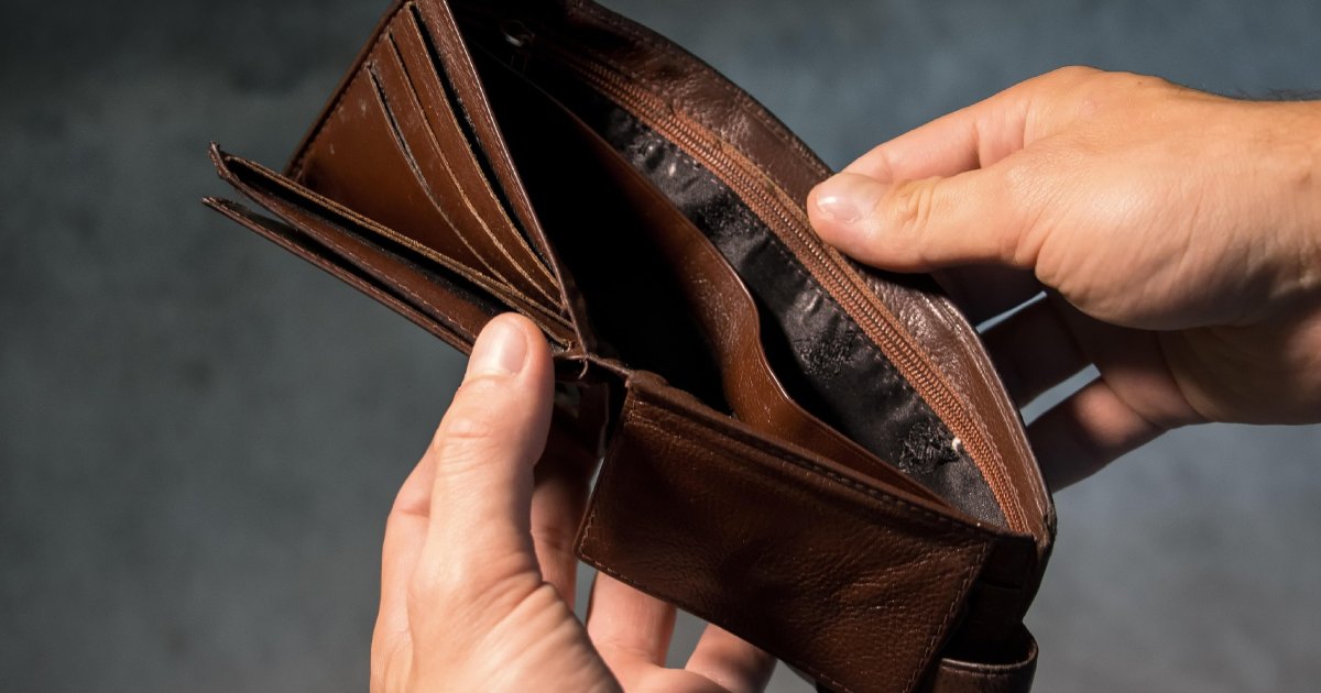 A hand holding an empty wallet.