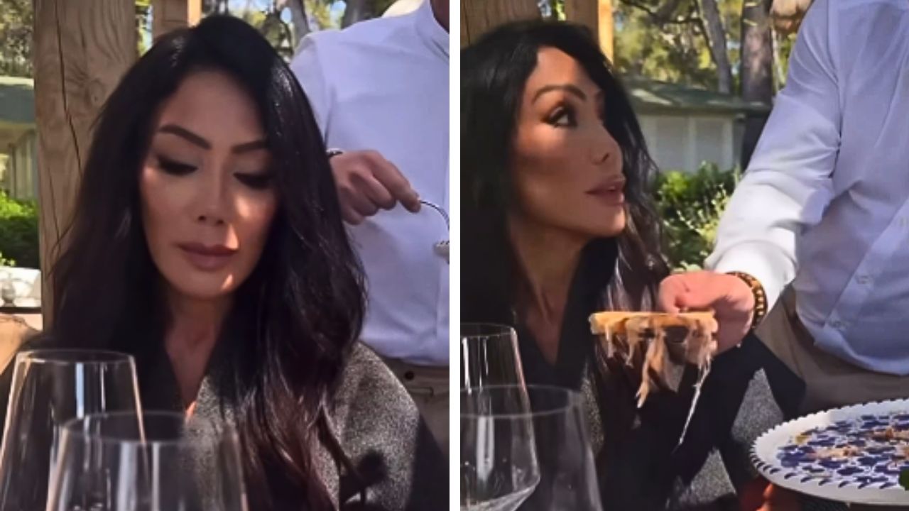 Ann Kaplan Mulholland sits at an outdoor restaurant as a server offers her a slice of pizza in the viral Cannes video.