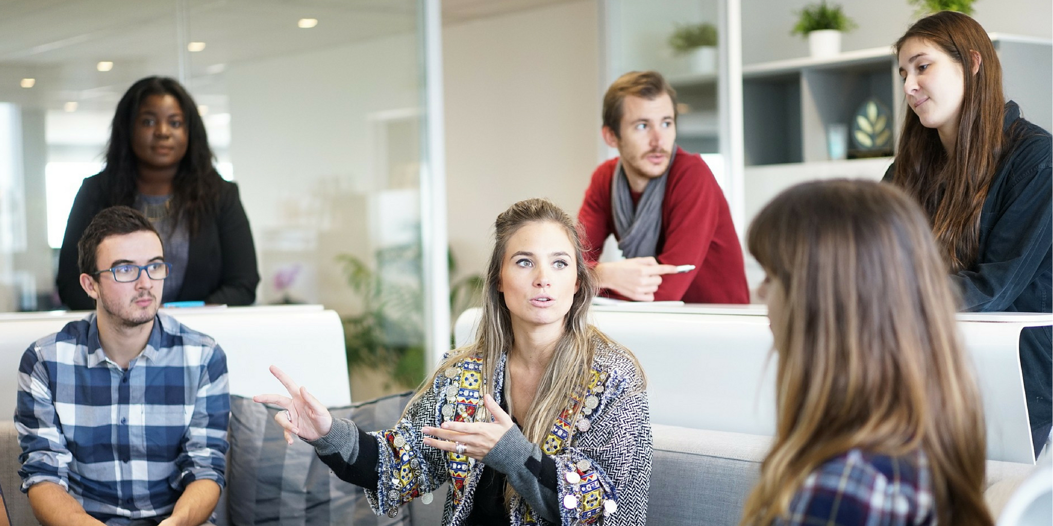 Men and women speaking at a desk in a workspace